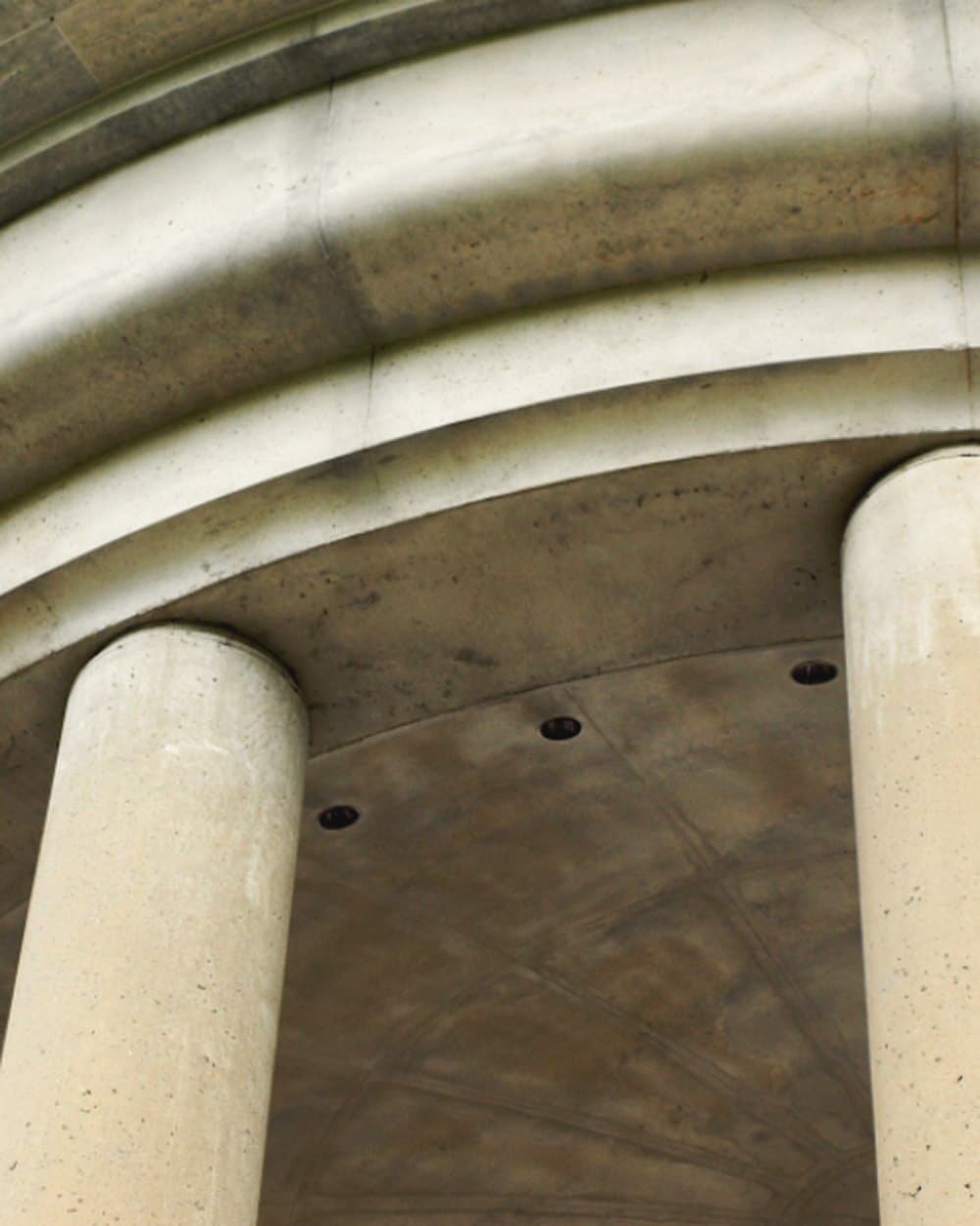 Concrete arch and columns seen from below.